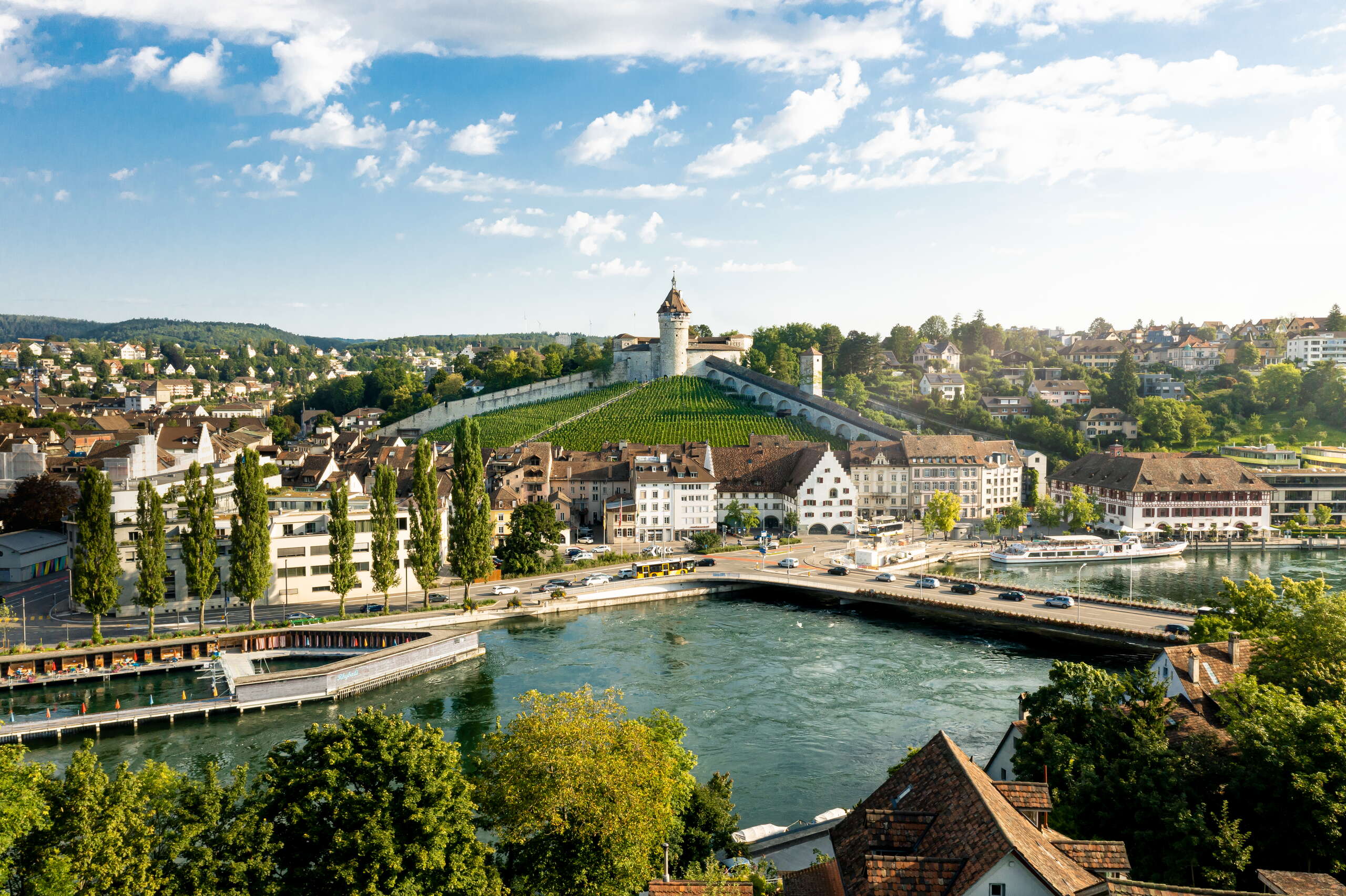 Man sieht den Munot im Zentrum und die Rhybadi am Rheinufer, sowie die Stadt Schaffhausen.